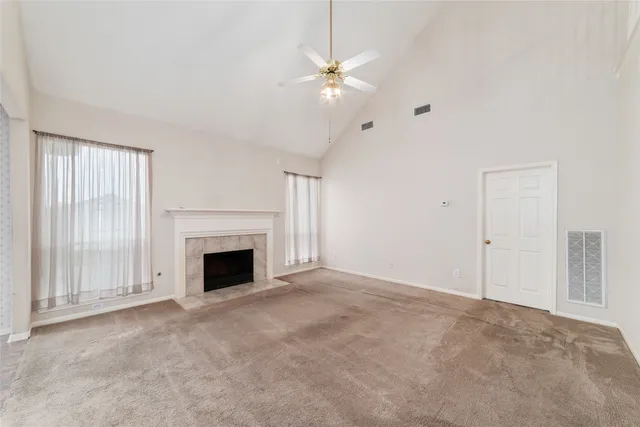wooden floor fireplace and windows in an empty room