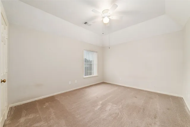 en empty room with windows and ceiling fan