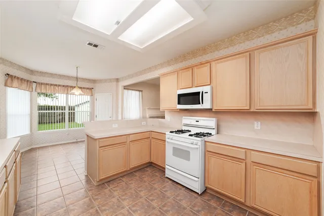 a kitchen with white cabinets sink and appliances