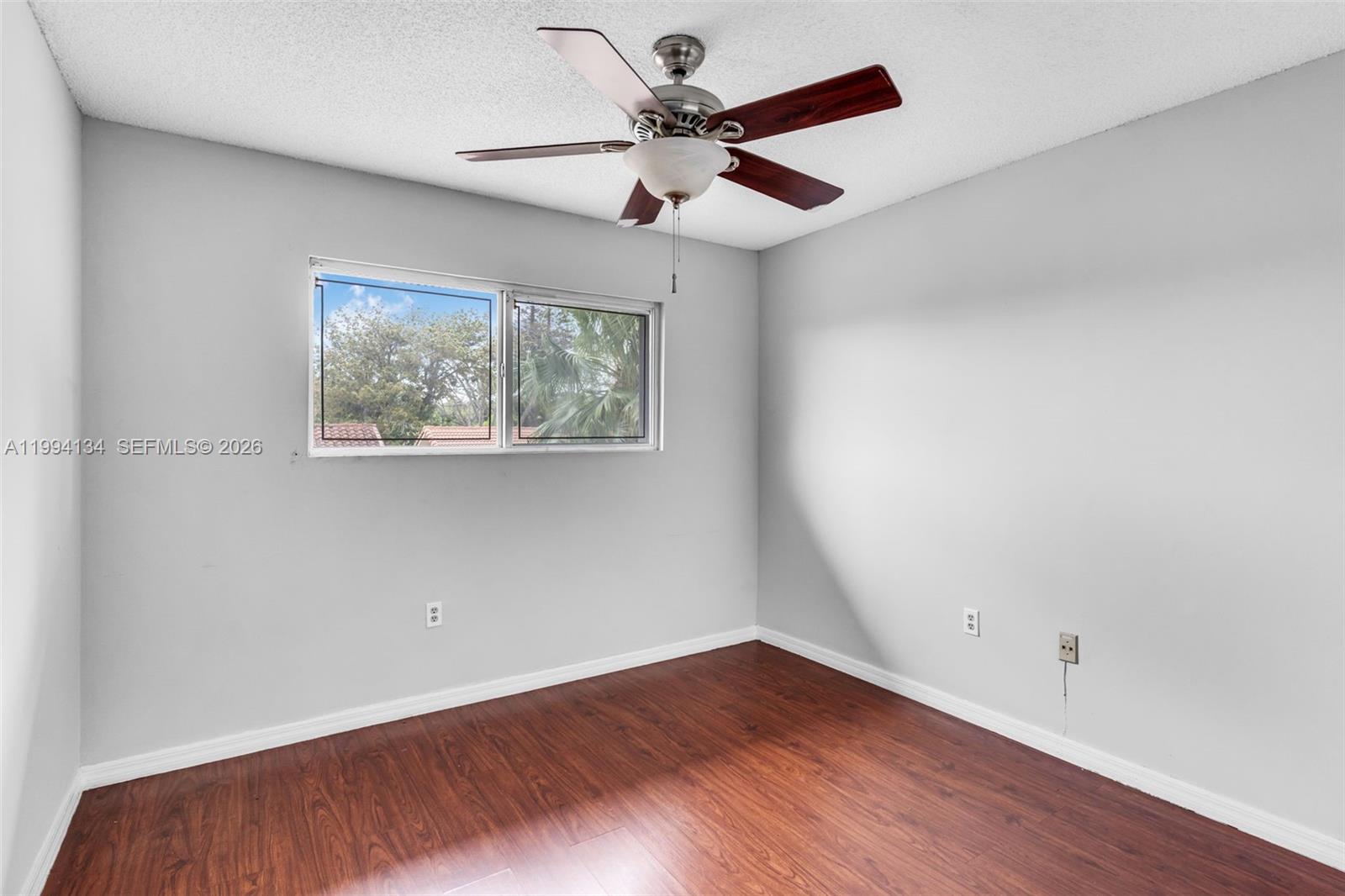 11319 Southwest 73rd Lane Miami, FL 33173 - Photo 12 of 43 wooden floor in an empty room with a window