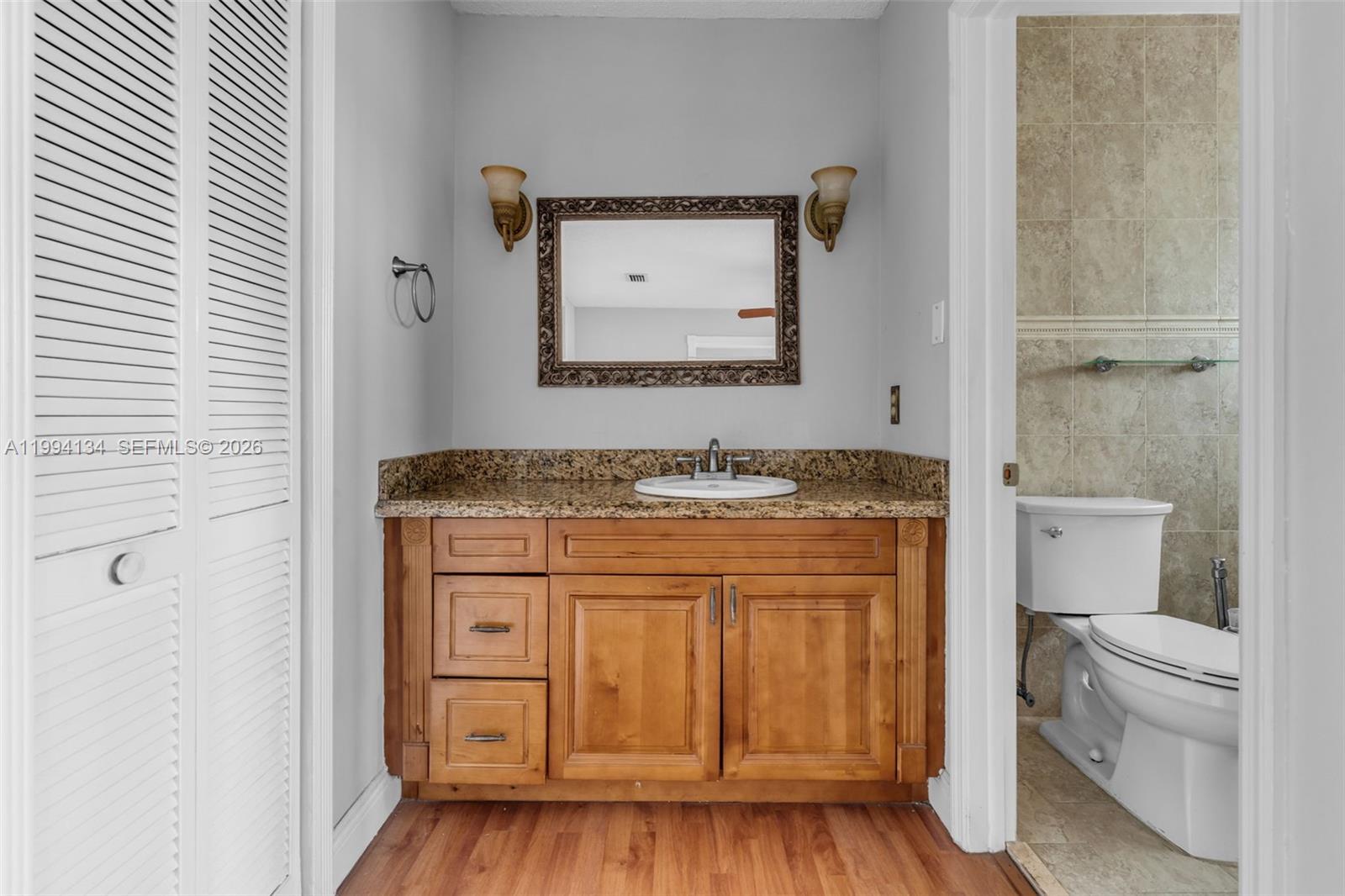 11319 Southwest 73rd Lane Miami, FL 33173 - Photo 17 of 43 a bathroom with a granite countertop sink a toilet and a mirror