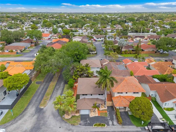 an aerial view of residential houses with outdoor space and parking