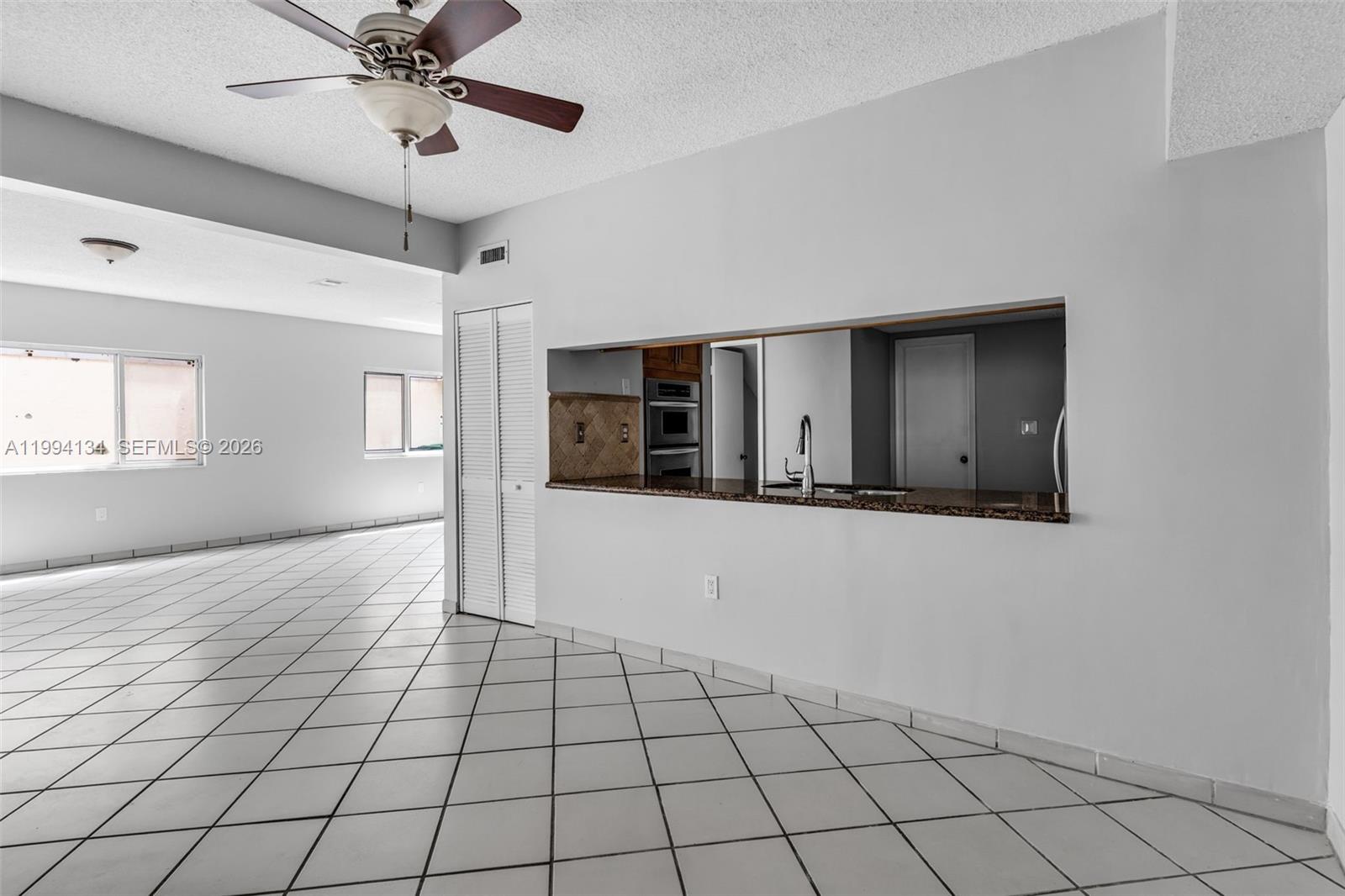 11319 Southwest 73rd Lane Miami, FL 33173 - Photo 5 of 43 a view of an empty room with window and chandelier fan