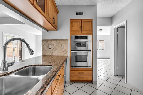 a kitchen with stainless steel appliances granite countertop a refrigerator and a sink