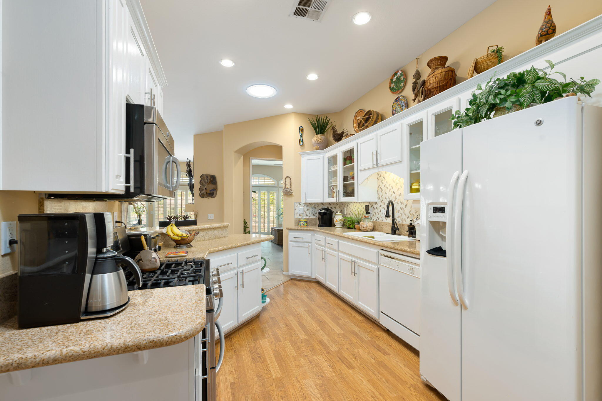 48908 Heifitz Drive Indio, CA 92201 - Photo 22 of 42 a kitchen with white cabinets and stainless steel appliances