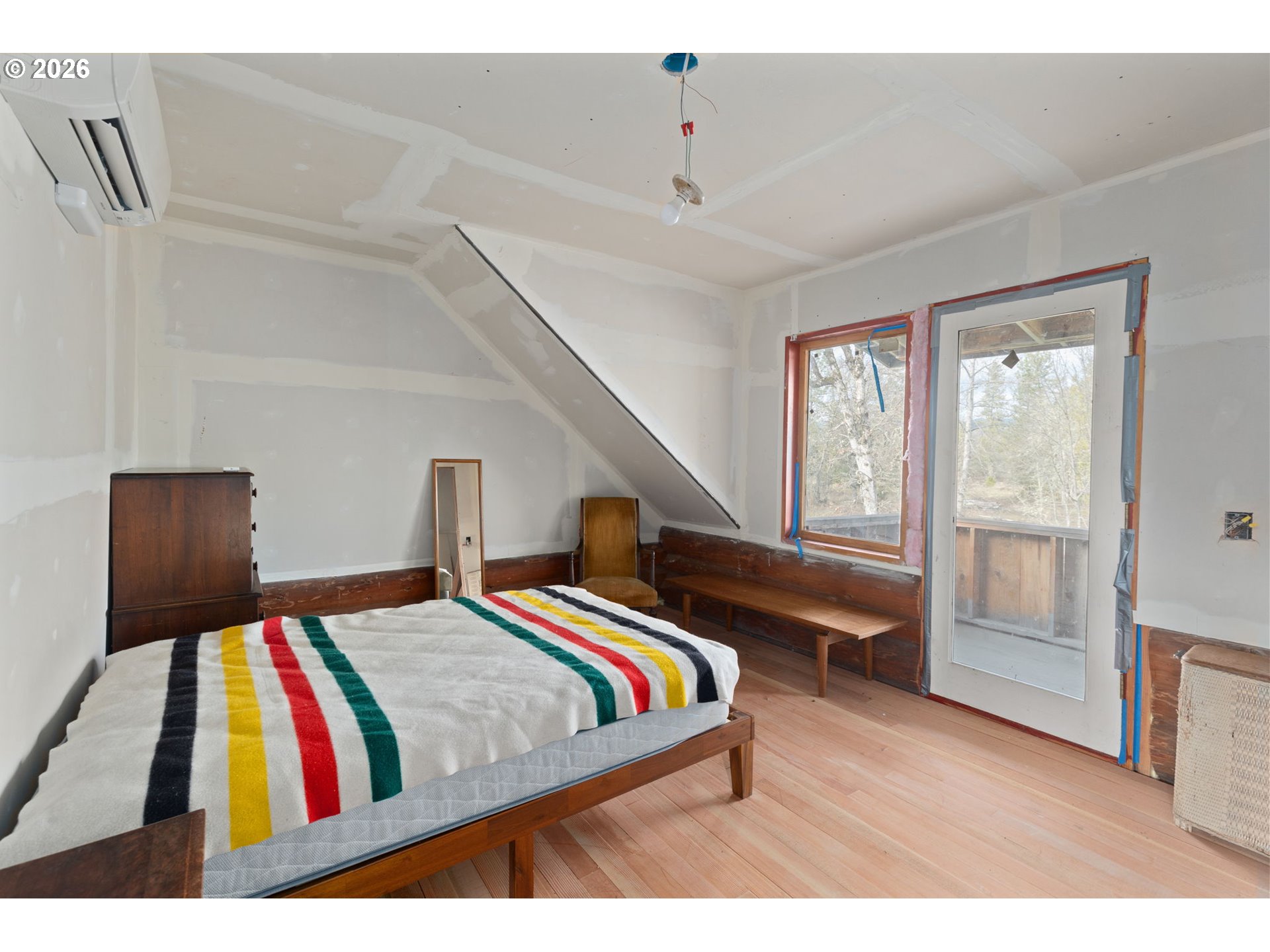 4420 Holland Loop Road Cave Junction, OR 97523 - Photo 23 of 46 a bedroom with a bed and a painting on the wall
