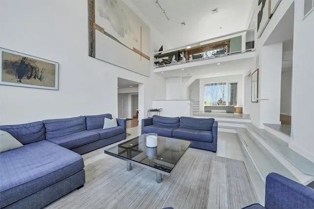 a living room with furniture and a view of kitchen