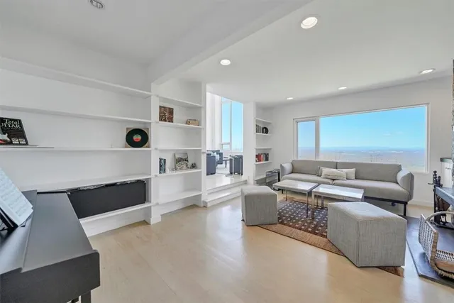 a living room with furniture and a view of kitchen