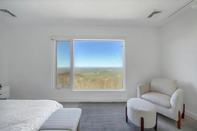 a bedroom with a bed and a couch with window