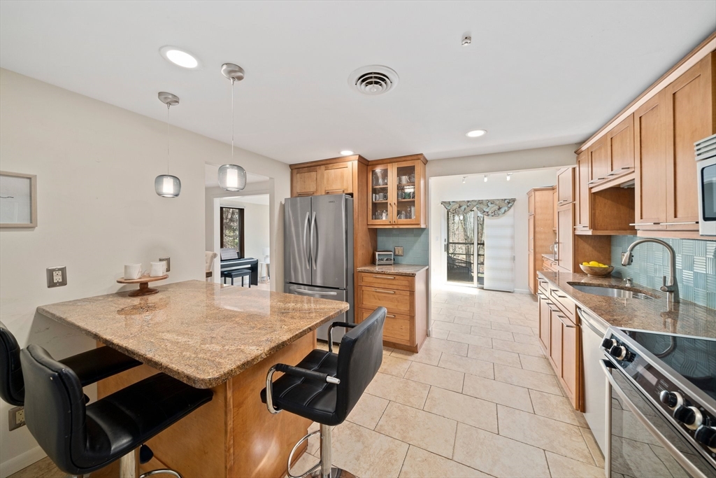 20 Condor Road Sharon, MA 02067 - Photo 4 of 41 a kitchen with stainless steel appliances granite countertop a stove a refrigerator a sink a dining table and chairs