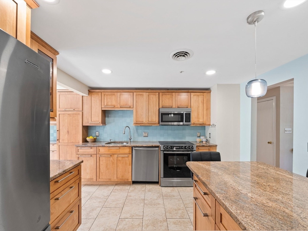 20 Condor Road Sharon, MA 02067 - Photo 8 of 41 a kitchen with stainless steel appliances granite countertop a stove top oven a sink dishwasher and a refrigerator with wooden cabinets