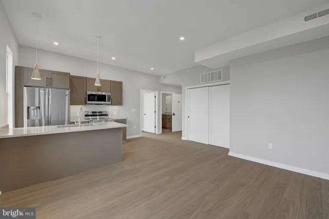 a view of kitchen with wooden floor and electronic appliances
