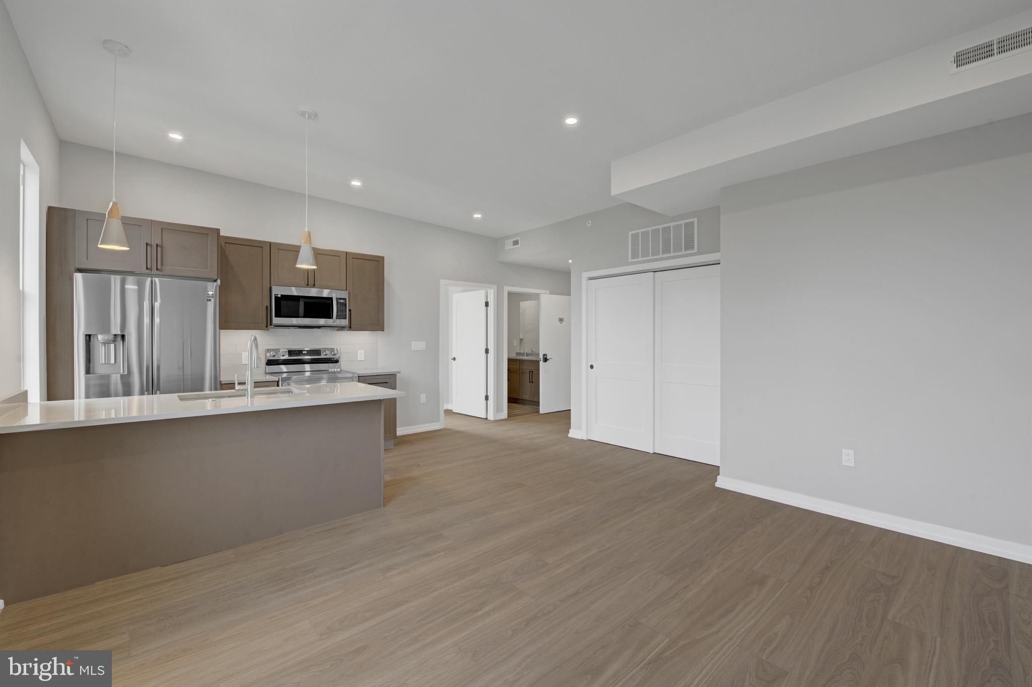 a view of kitchen with wooden floor and electronic appliances