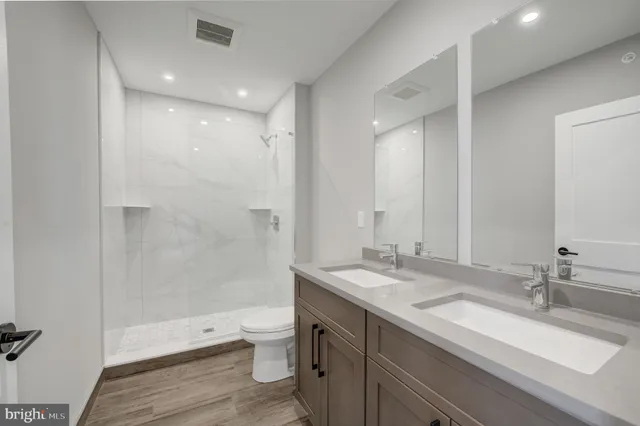 a bathroom with a double vanity sink toilet and shower