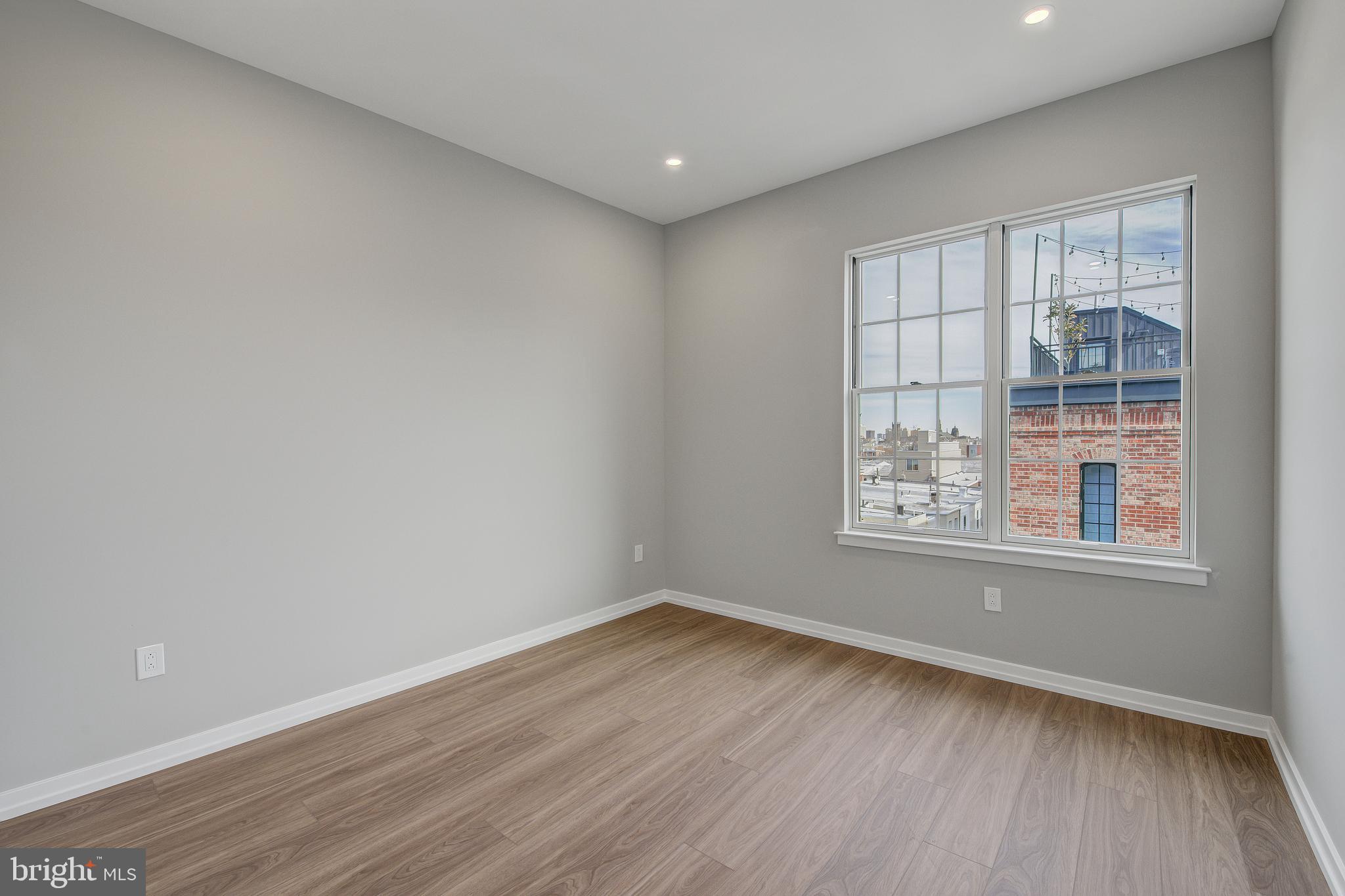 2445 Innovator Way, Unit 4I Philadelphia, PA 19146 - Photo 9 of 12 an empty room with wooden floor and windows