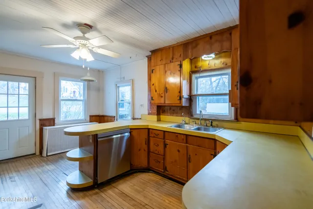 a view of a kitchen counter top space with a sink and wooden floor
