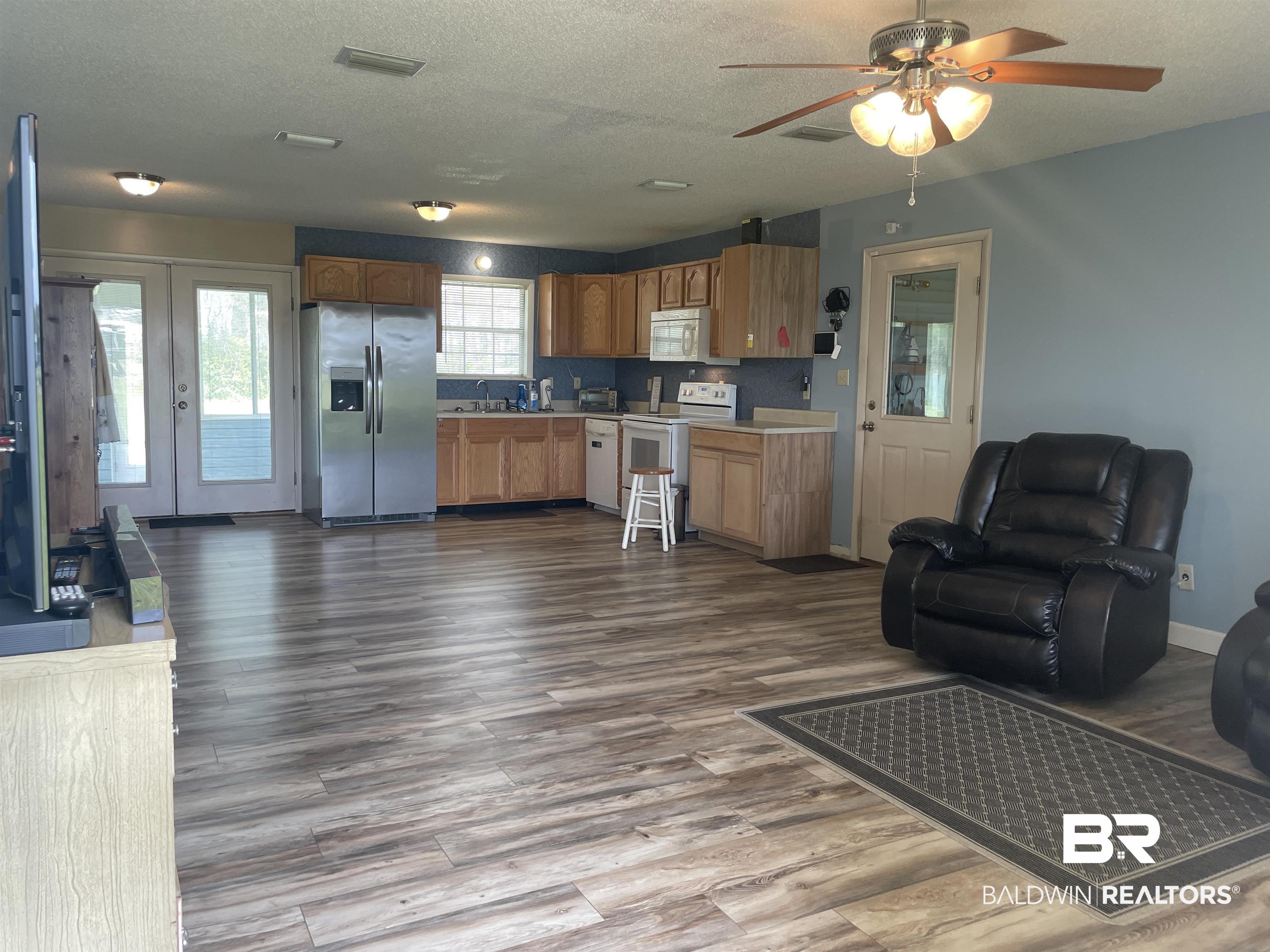 739 Smithfield Road Atmore, AL 36502 - Photo 17 of 18 Kitchen featuring open floor plan, visible vents, dark wood-type flooring, and white appliances