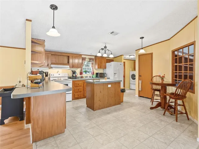 a room with stainless steel appliances kitchen island granite countertop furniture and a view of kitchen