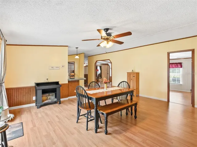 a view of a livingroom with furniture a fireplace wooden floor and a window