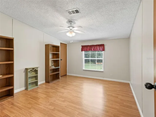 a view of an empty room with a window and closet