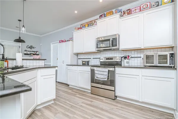 a kitchen with stainless steel appliances granite countertop a stove a sink and a microwave