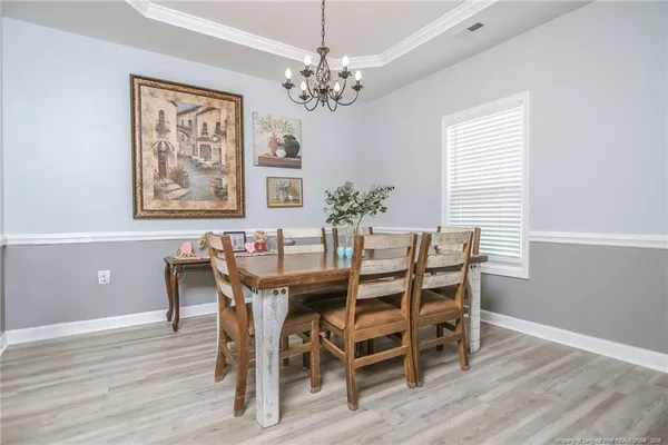 a view of a dining room with furniture and chandelier