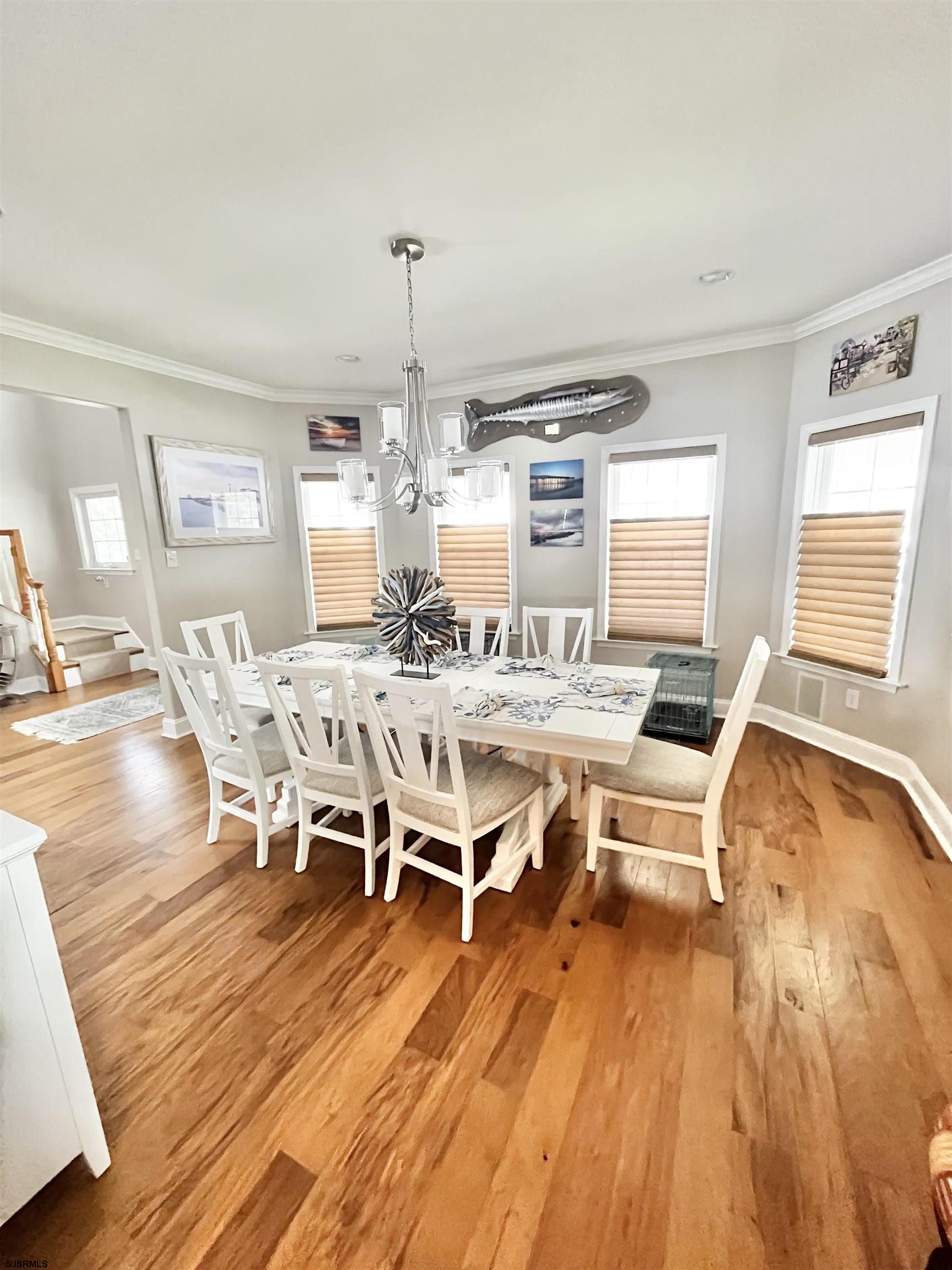 38 Walnut Road Ocean City, NJ 08226 - Photo 14 of 37 a dining room with wooden floor a chandelier a glass table and chairs
