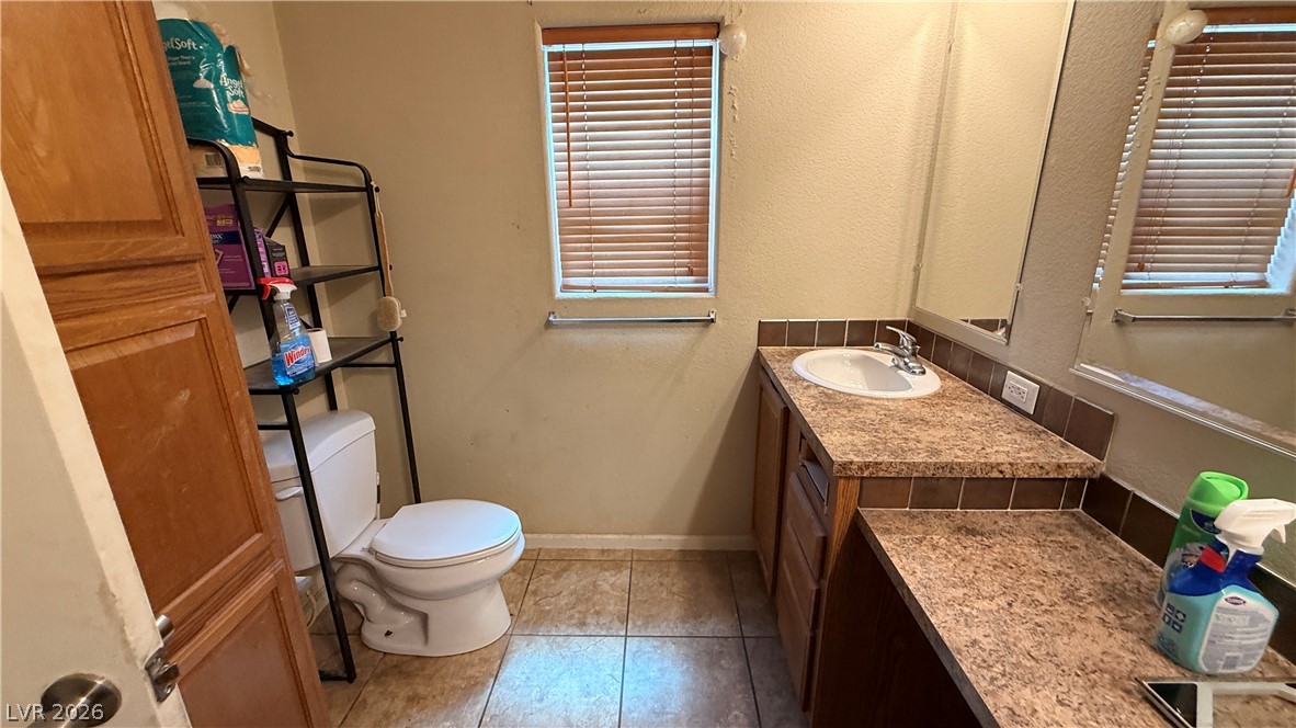 855 Spring Road Indian Springs, NV 89018 - Photo 10 of 13 Tiled flooring and a laminate-topped vanity define this functional bathroom space.