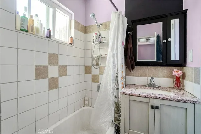 a bathroom with a granite countertop sink a mirror and a bathtub