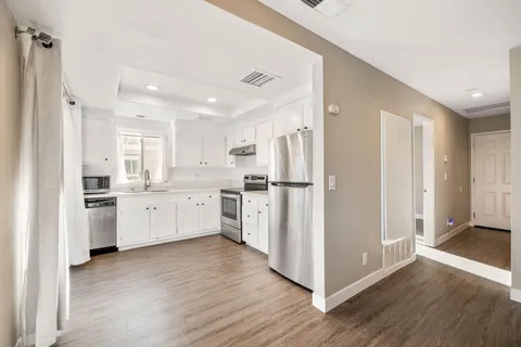 a kitchen with white cabinets and white stainless steel appliances