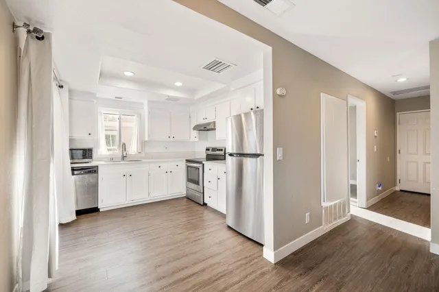 a kitchen with white cabinets and white stainless steel appliances