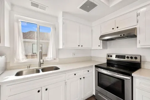 a view of a hallway with white walls and stairs