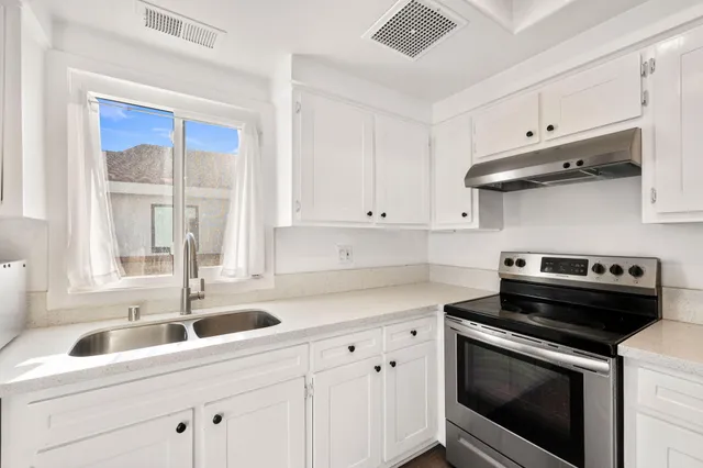 a view of a hallway with white walls and stairs