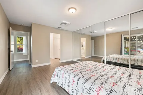 a bed sitting in a bedroom and a large window with balcony view