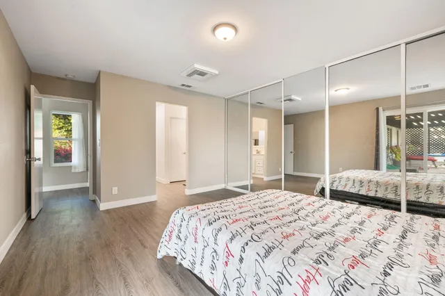 a bed sitting in a bedroom and a large window with balcony view