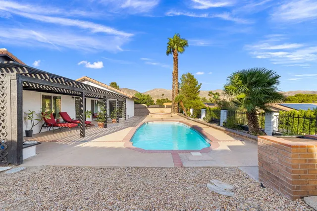 a view of a house with swimming pool and sitting area