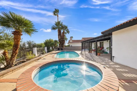 a view of a house with swimming pool and sitting area