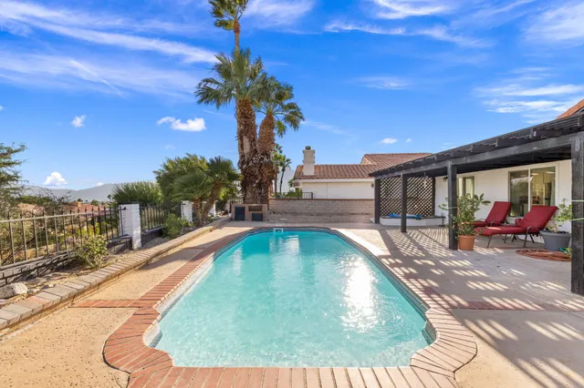 a view of a house with sitting area and swimming pool