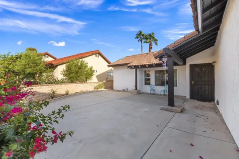 a backyard of a house with flower plants and trees