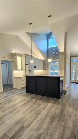 a view of a kitchen with a window and wooden floor