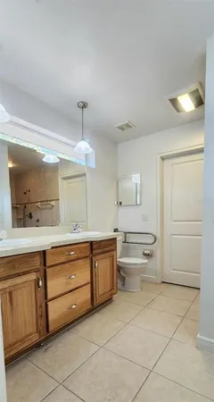 a bathroom with a granite countertop sink mirror and toilet