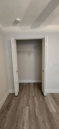 an empty room with wooden floor and closet