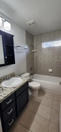 a bathroom with a granite countertop toilet a sink and mirror