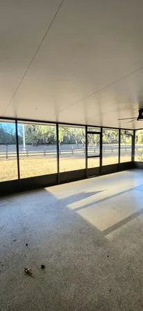 a view of an empty room with a floor to ceiling window next to a road