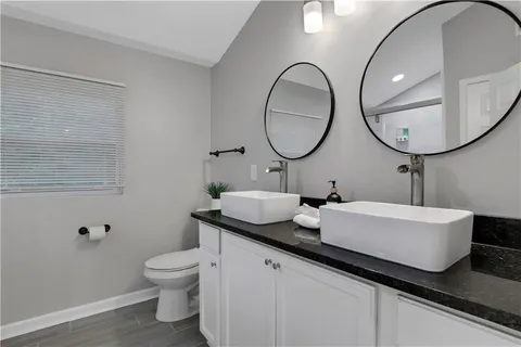 a bathroom with a toilet a sink and mirror