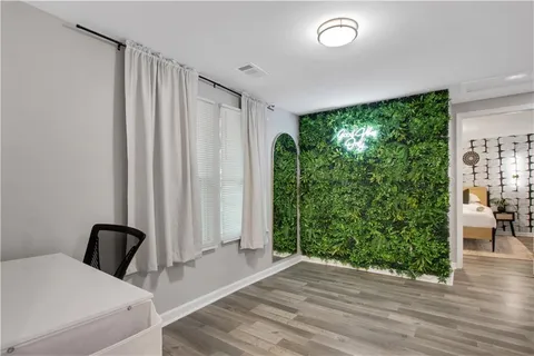 a bedroom with a bed and a flat tv screen on dresser