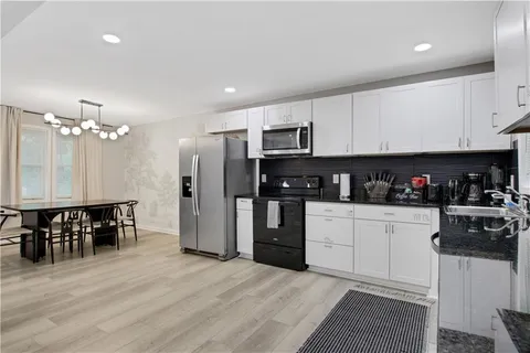 a bathroom with a granite countertop sink a toilet and shower