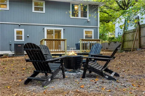 a view of a dinning table and chairs in back yard of a house