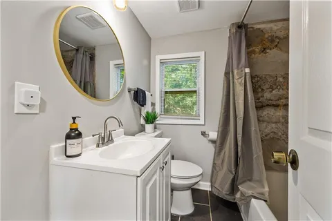 a bathroom with a toilet sink and mirror