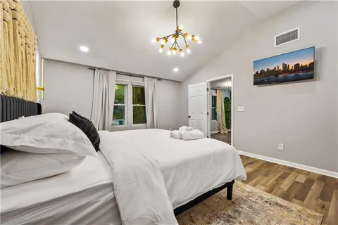 a bedroom with a large bed and a chandelier